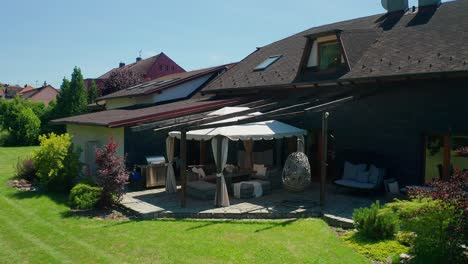 Luftdrohnenaufnahme-Von-Garten-Und-Terrasse-Mit-Möbeln-Am-Familienhaus-Im-Sommer
