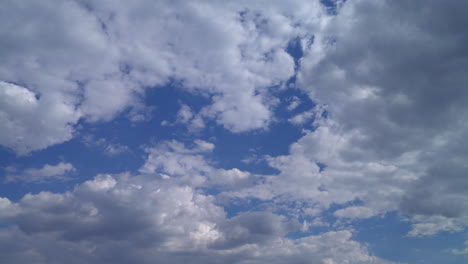 Fluffy-white-clouds-drifting-across-a-clear-blue-sky