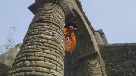 Female-redhead-wearing-plague-mask-appearing-from-behind-stone-archway-then-staring-into-camera
