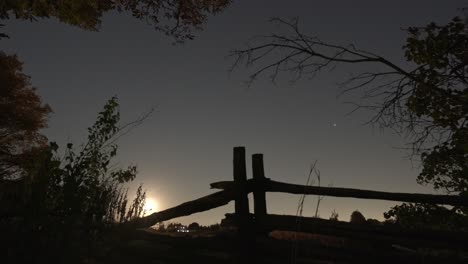 Zeitraffer-Eines-Wunderschönen-Mondaufgangs,-Vollmond-über-Einem-Alten-Bauernhofzaun