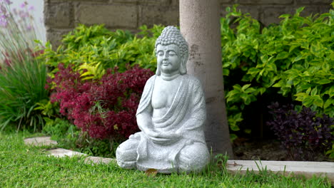 Ruhige-Szene-Mit-Einer-Steinernen-Buddha-Statue-In-Einer-Ruhigen-Gartenumgebung,-Die-Ein-Gefühl-Von-Frieden-Und-Spiritualität-Ausstrahlt