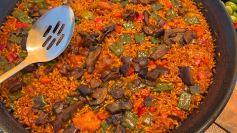 Traditional-Spanish-Paella-dish-with-vegetables-in-a-restaurant,-tasty-cooked-rice-with-vegetables,-Marbella-Spain,-4K-top-view-shot