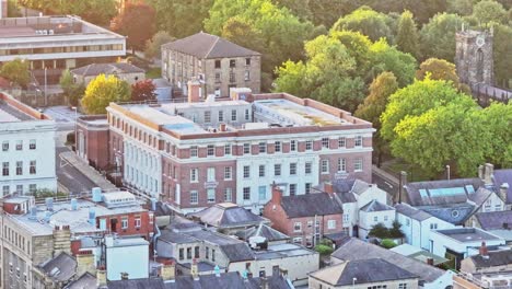 Drone-ascends-city-centre-of-Barnsley,-classic-English-town-with-bright-sunlight-spread-across-historic-buildings