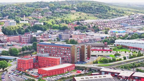 Red-brown-worn-down-building-in-front-of-sprawling-urban-homes-on-hillside-at-susnet