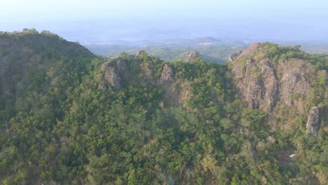 Aerial-view-of-rocky-hill-covered-with-dense-trees