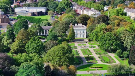 Aerial-pullback-reveals-stunning-garden-landscape-of-Brodsworth-Hall,-Doncaster-England