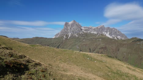 Un-Dron-Vuela-Sobre-Verdes-Colinas-Montañosas-En-Austria,-Revelando-Un-Valle-Con-Pequeños-Caminos-Y-Casas,-Que-Conducen-A-Un-Majestuoso-Alp-En-Un-Día-Despejado