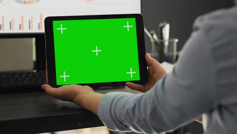 Worker-examines-greenscreen-on-tablet