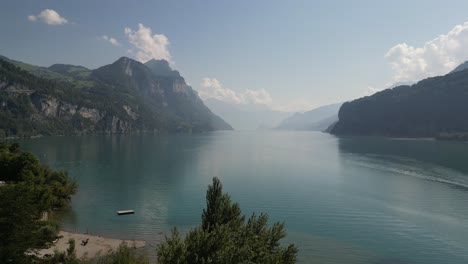 Drone-flying-over-along-Weesen-town-based-near-shore-of-Walensee-lake,-Switzerland