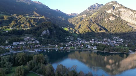 An-Alpine-village-by-the-mountains-and-Walensee-Lake-in-aerial-panorama-view