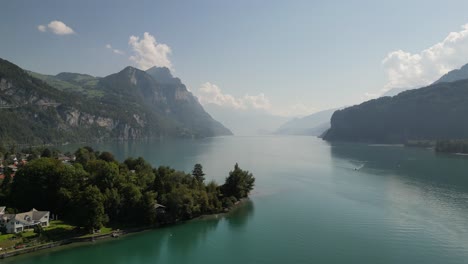 Beautiful-view-from-drone-flying-over-Weesen-town-based-near-shore-of-Walensee-lake,-Switzerland-with-blue-sky