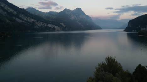 A-stunning-view-of-Lake-Walensee's-tranquil-waters-and-mountain-backdrop-at-sunrise