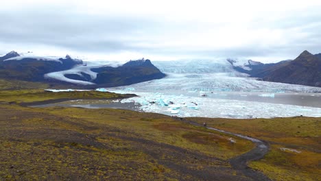 Aerial-rising-shot-of-the-Icebergs-melting-in-the-lagoon-at-Fjallsárlón-Glacier