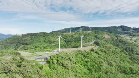 Majestätische-Luftaufnahmen-Von-Langgestreckten-Windkraftanlagen-Auf-Sanften-Hügeln
