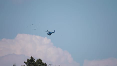 Ein-Hubschrauber-Am-Himmel,-Der-Sich-Dem-Vogelschwarm-Nähert