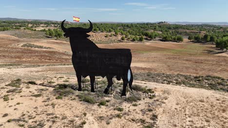 Aerial-drone-view-of-a-huge-billboard-bull-with-the-Spanish-flag-waving-in-its-head