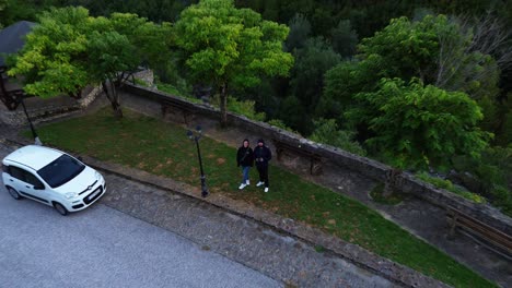 Drone-view-of-couple-in-Greece-countryland-in-Nestorio-village,-the-place-where-Nestorio-River-Party-is-happening