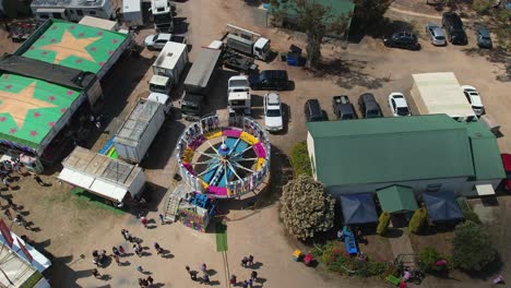 Yarrawonga,-Victoria,-Australia---7-October-2023:-Aerial-rising-up-view-of-people-on-the-spinning-Tornado-amusement-ride-at-the-Yarrawonga-Show