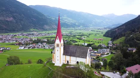 Kirchturm-Mit-Blick-Auf-Ein-Weitläufiges-Taldorf,-Umgeben-Von-Bergen