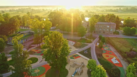 Aerial-tracking-shot-of-a-kids-playground-park-on-a-colorful-summer-sunset