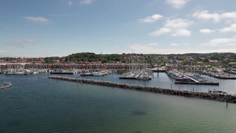 Small-Marina-and-Coastal-Town-in-Cinematic-Aerial-View-Sailboats-Boats