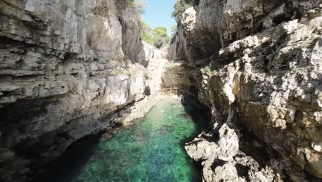 Secluded-cove-with-turquoise-waters-between-rugged-cliffs
