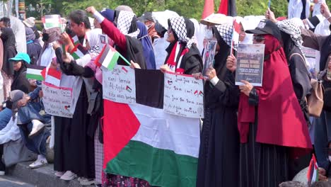 Protesters-with-Palestinian-flags-and-signs-with-inscriptions-at-the-protest-in-Jakarta,-Indonesia