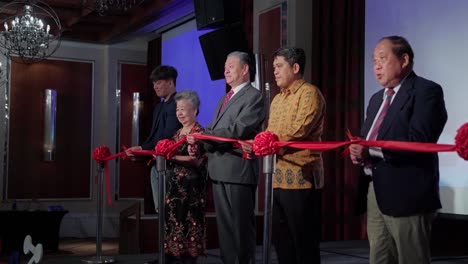 Group-of-Business-People-Cutting-Red-Ribbon-During-Grand-Opening-Ceremony
