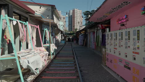 Walking-POV-Traveling-Through-Gyeongamdong-Railroad-Town-in-Gunsan,-Railway-Tracks-Through-Narrow-Street-With-Old-Retro-Korean-Shops