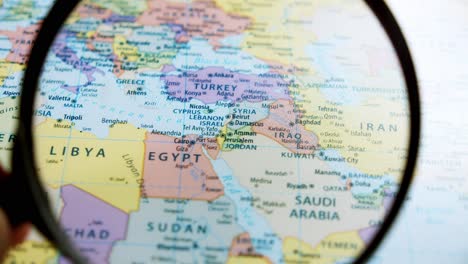 Using-a-magnifying-glass,-showing-a-close-up-of-the-countries-in-the-Middle-East-such-as-Israel,-Egypt,-Iraq,-Iran,-Lebanon,-Jordan,-Kuwait,-Saudi-Arabia,-and-many-more