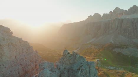A-solitary-individual-on-Piccola-Cir-witnesses-dawn's-embrace,-as-the-sun-illuminates-the-vast-Dolomites'-expanse