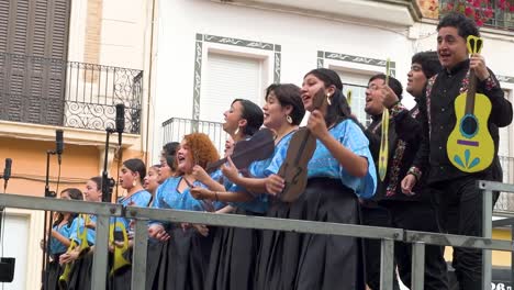 Side-view-of-Mexican-choir-group-singing-on-a-stage-outdoors