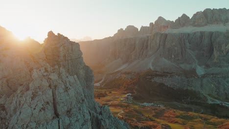 As-the-sun-casts-its-early-morning-glow,-the-Sella-Stock-and-Pisciadù-cliffs-in-the-Dolomites-emerge-from-the-shadows,-revealing-their-majestic-formations