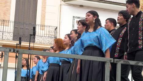 Side-view-of-choir-group-singing-on-stage-in-a-city-square