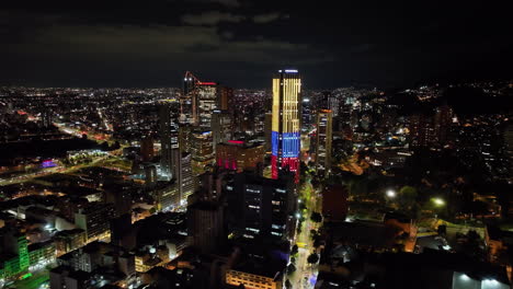 Aerial-view-around-illuminated-skyscrapers,-night-in-downtown-Bogota,-Colombia