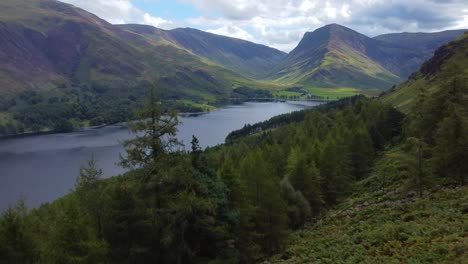Aerial-drone-video-in-4K-of-a-beautiful-landscape-with-lake-forest-and-mountains---taken-in-Buttermere,-Lake-District-UK