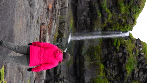 Frau-Bewundert-Die-Wunderschöne-Färöische-Natur-Am-Wasserfall-Von-Mikladalur,-Kalsoy