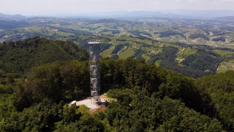 Telecommunication-tower-on-hill-and-Podcertek-rural-Slovenian-landscape,-sunny-day