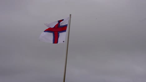 Close-up-of-Faroese-flag-blown-by-strong-gusts-of-winds,-stormy-weather