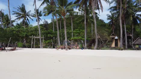 Tourists-people-relaxing-on-hammocks-at-Coco-Beach-resort-huts-of-Bulalacao-island-with-Palm-trees-and-clear-water