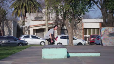 An-adult-man-wearing-headphones-practicing-tricks-on-a-skateboard