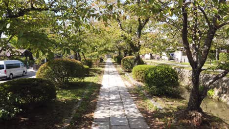 POV-Walk-Through-Philosopher's-Path-Road-in-Kyoto-Japan,-Autumn,-Green-Foliage-at-Travel-Landmark