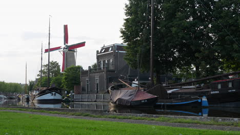 Ikonische-Getreidemühle-Mill-De-Rodee-Lion-Und-Alte-Boote-Auf-Turfsingel-In-Gouda,-Niederlande