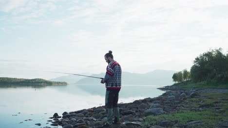 A-Man-With-Fishing-Road-At-The-Lake-Near-Vangsvika,-Senja-Norway