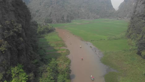 Flug-über-Den-Fluss-Bei-Ninh-Binh,-Umgeben-Von-Grünen-Reisfeldern-In-Vietnam,-Luftaufnahme
