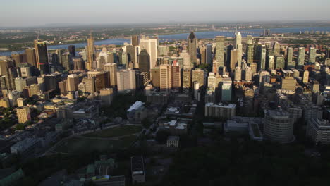 Flying-sideways-in-front-of-the-Metropolis-of-Montreal,-golden-hour-in-Canada---Aerial-view