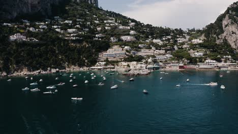 Vista-Aérea-De-Los-Barcos-Que-Bordean-Capri,-La-Diversa-Costa-De-Italia