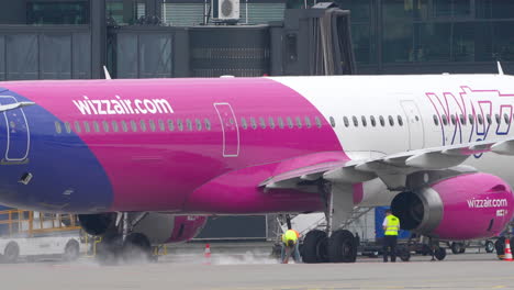 Vibrant-pink-airplane-being-serviced-on-tarmac---wizzair-on-Gdańsk-airport