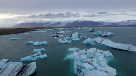 Aerial-of-many-icebergs-pieces-floating-in-Jokulsarlon-glacial-lake,-Iceland