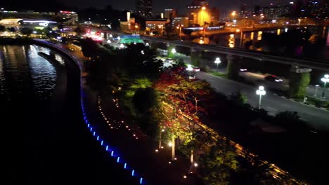 Cinematic-Aerial-view-of-Cars-driving-on-Sentosa-boardwalk-road-at-night,-Singapore